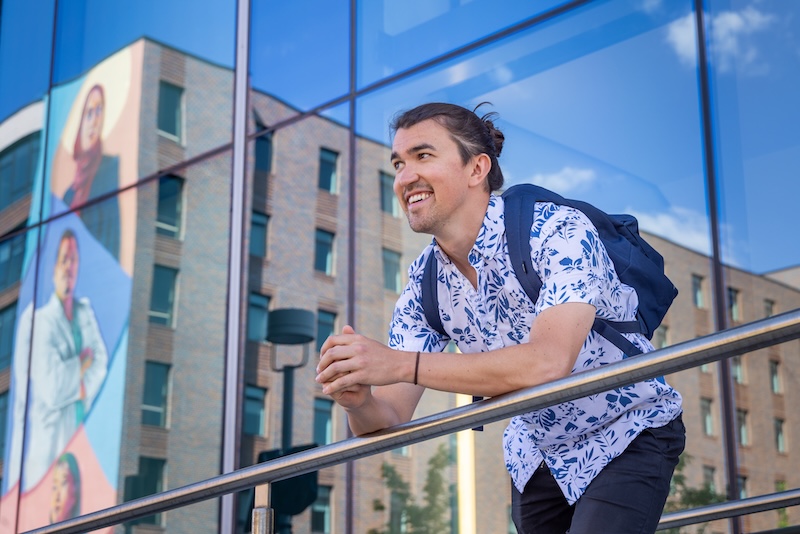 Student looking at campus from a balcony.