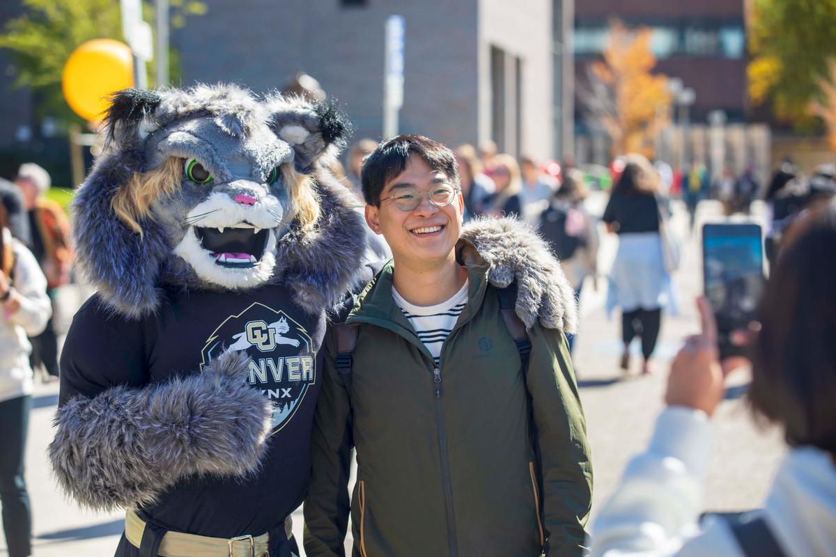 CU Denver Student stands with Milo mascot